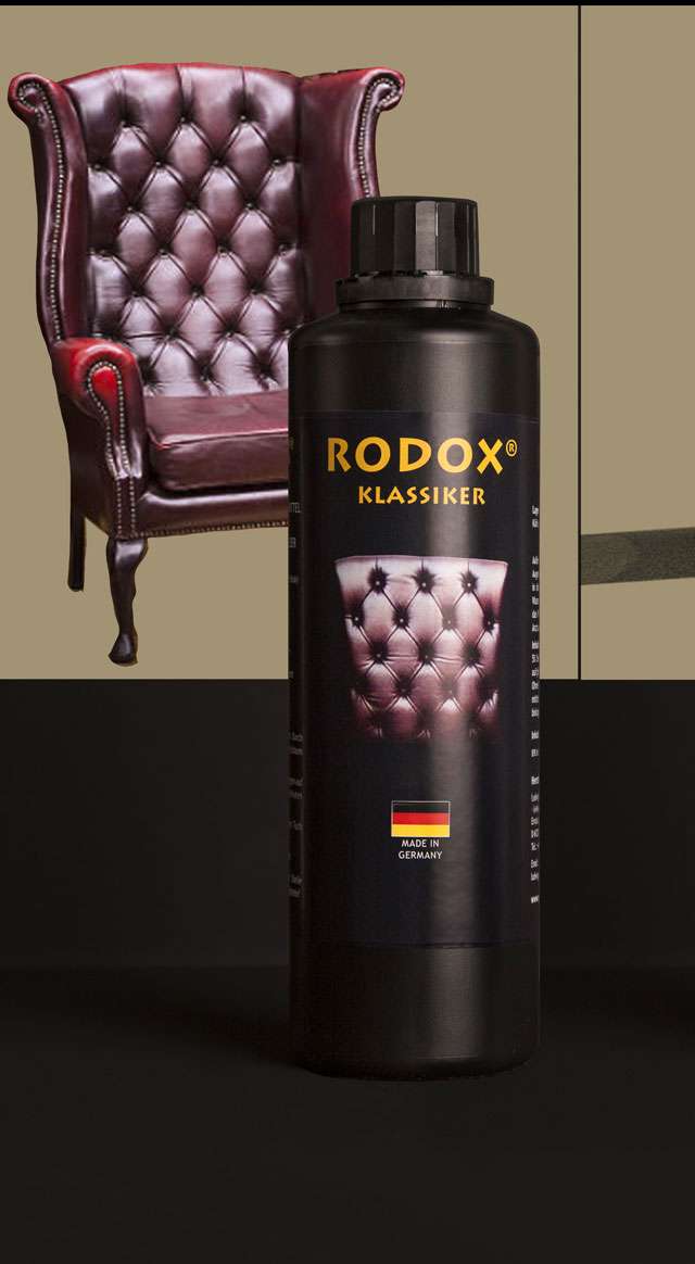 Ein gut gepflegter glänzender Ledersessel in Kastanienfarbe mit glattem Leder auf einem beigen Hintergrund. Im Vordergrund steht eine Flasche von RODOX® Pflege- und Reinigungsmittel für Ledermöbel, Autoleder und Kunstleder.